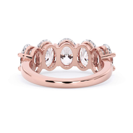 A picture of a five stone diamond wedding ring with oval shape diamonds that are shared prong set in rose gold on a white background with a view of the underside of the ring.