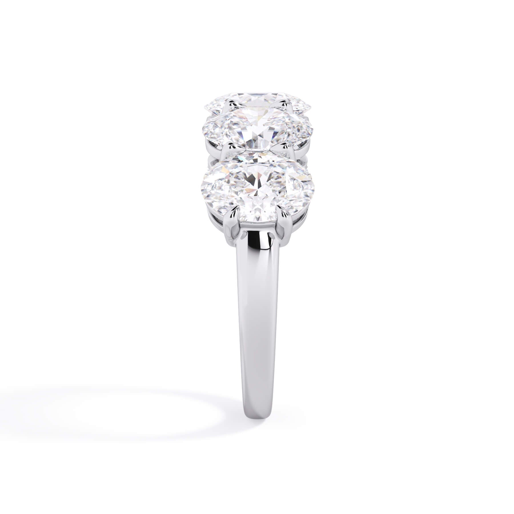 A picture of a five stone diamond wedding ring with oval shape diamonds that are shared prong set in white gold or platinum on a white background with a side profile view.