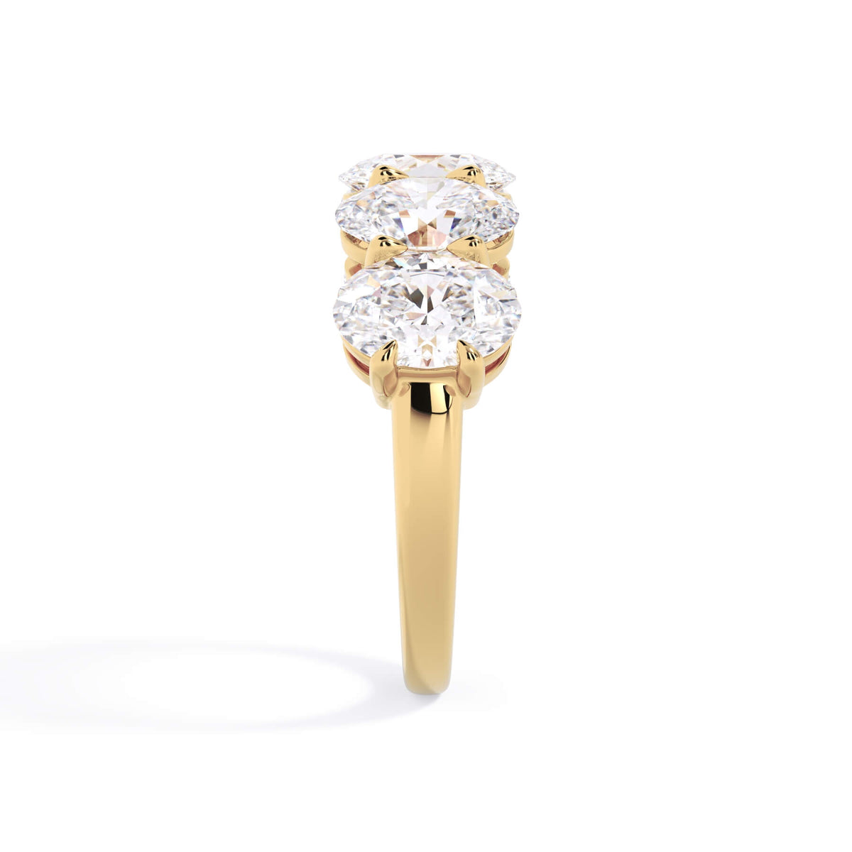 A picture of a five stone diamond wedding ring with oval shape diamonds that are shared prong set in yellow gold on a white background with a side profile view.