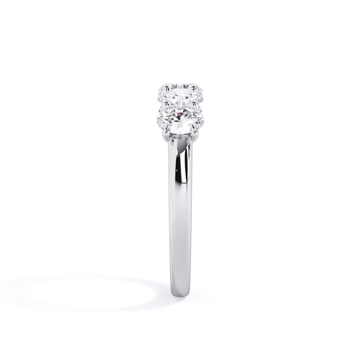 A picture of a five stone diamond wedding ring with oval shape diamonds that are u prong set in white gold or platinum on a white background with a side profile view.