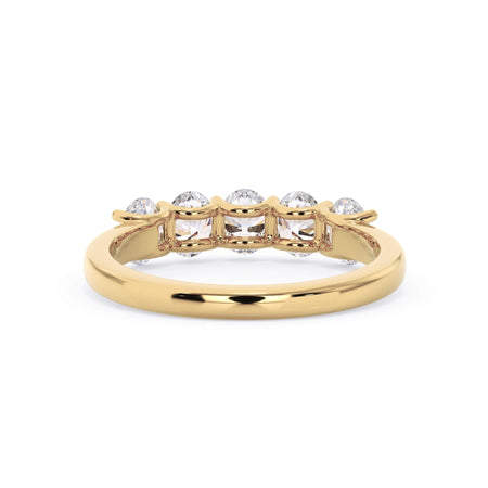 A picture of a five stone diamond wedding ring with oval shape diamonds that are u prong set in yellow gold on a white background with a view of the underside of the ring.