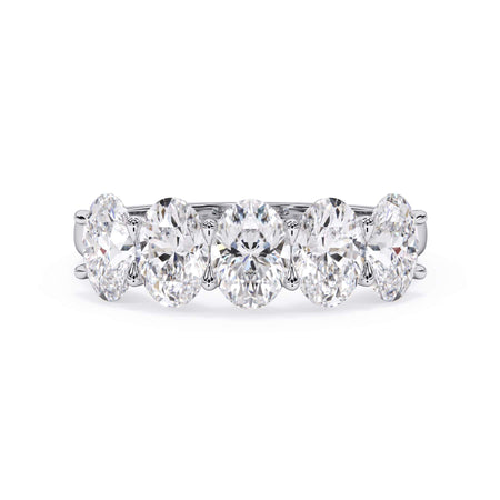 A picture of a five stone diamond wedding ring with oval shape diamonds that are u prong set in white gold or platinum on a white background with the ring facing forward, lying down.