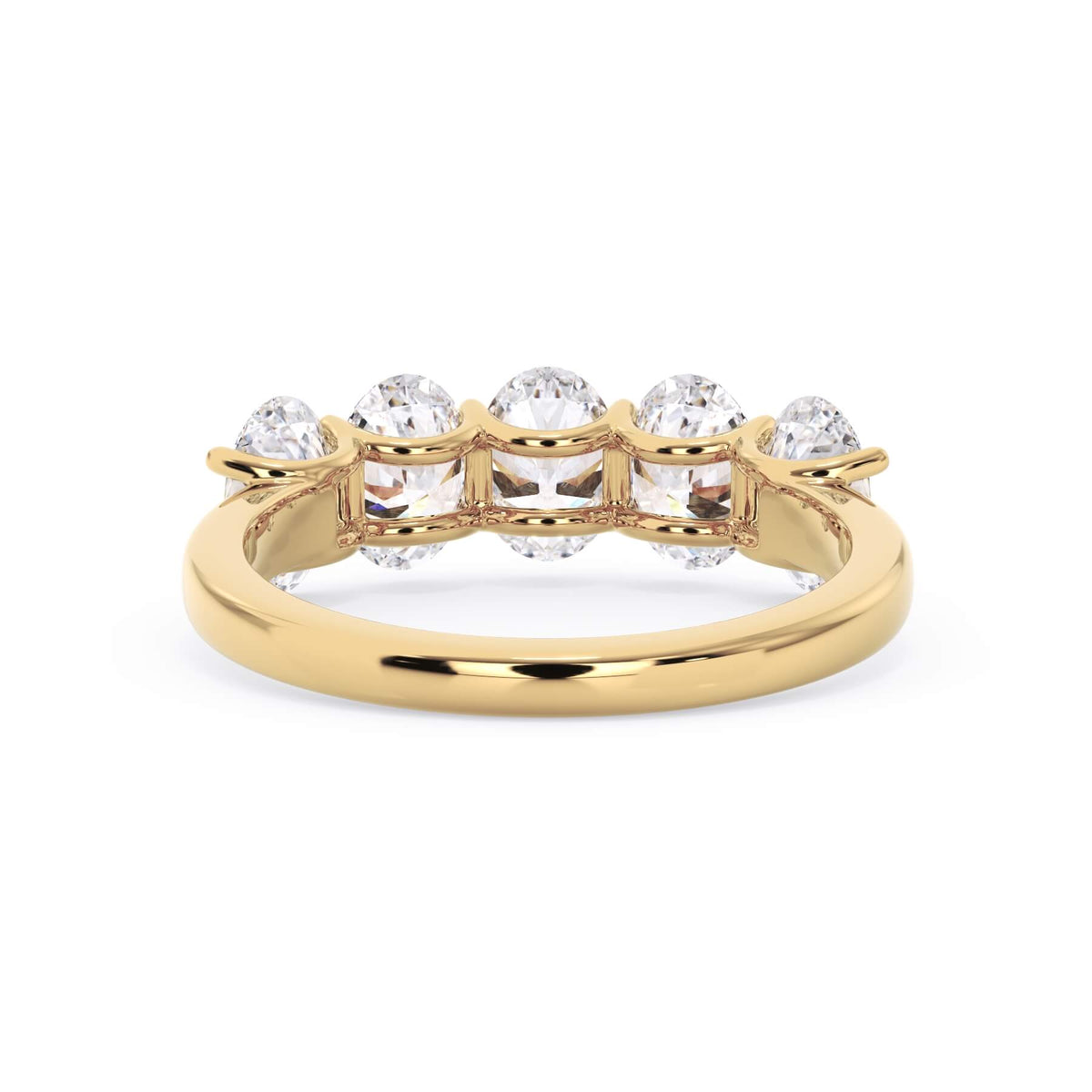 A picture of a five stone diamond wedding ring with oval shape diamonds that are u prong set in yellow gold on a white background with a view of the underside of the ring.