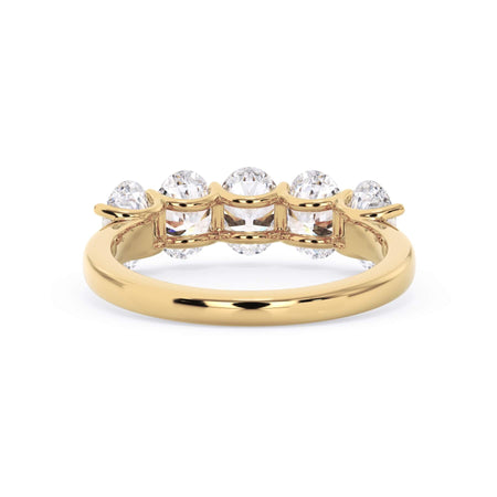 A picture of a five stone diamond wedding ring with oval shape diamonds that are u prong set in yellow gold on a white background with a view of the underside of the ring.