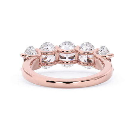 A picture of a five stone diamond wedding ring with oval shape diamonds that are u prong set in rose gold on a white background with a view of the underside of the ring.