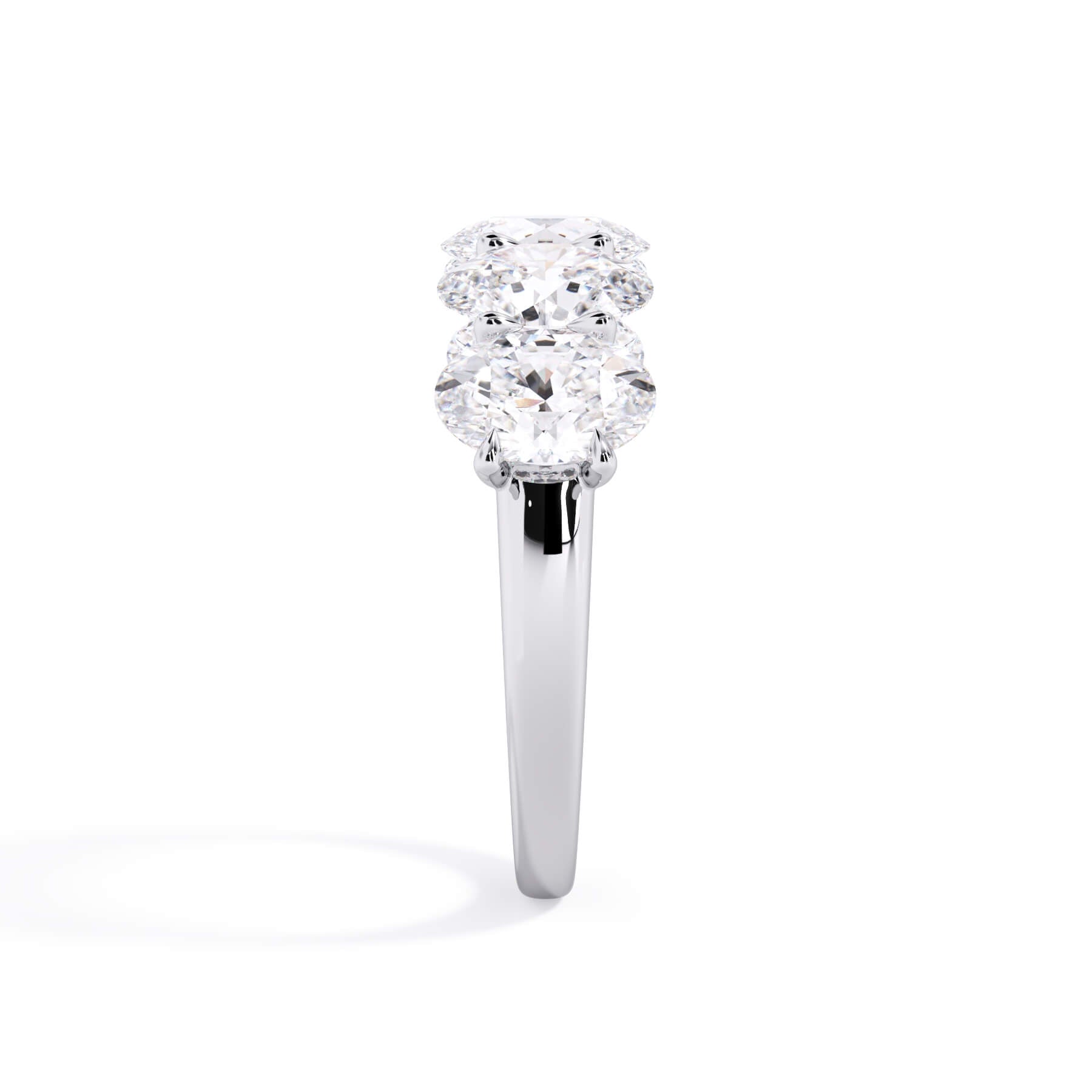 A picture of a five stone diamond wedding ring with oval shape diamonds that are u prong set in white gold or platinum on a white background with a side profile view.