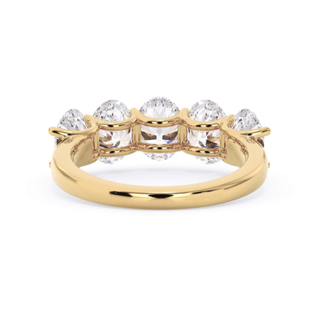 A picture of a five stone diamond wedding ring with oval shape diamonds that are u prong set in yellow gold on a white background with a view of the underside of the ring.