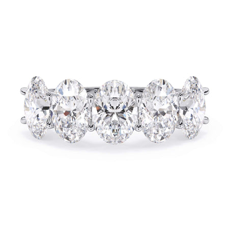 A picture of a five stone diamond wedding ring with oval shape diamonds that are u prong set in white gold or platinum on a white background with the ring facing forward, lying down.