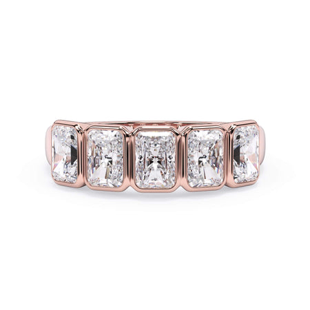 A picture of a five stone diamond wedding ring with radiant cut diamonds that are bezel set in rose gold on a white background with the ring facing forward, lying down.