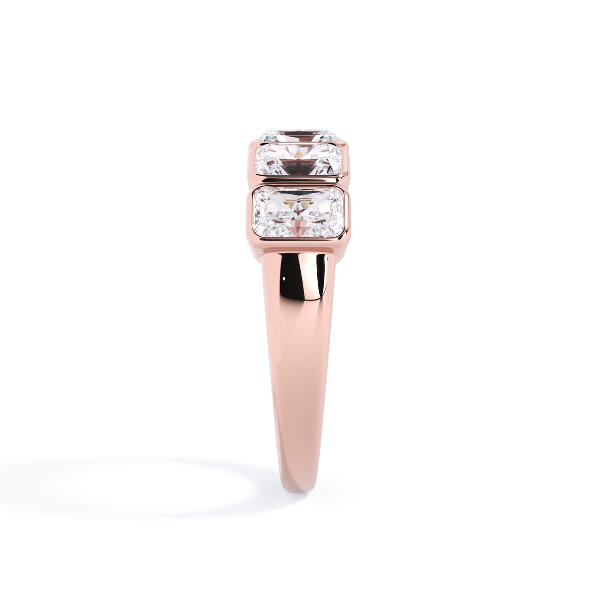 A picture of a five stone diamond wedding ring with radiant cut diamonds that are bezel set in rose gold on a white background with a side profile view.
