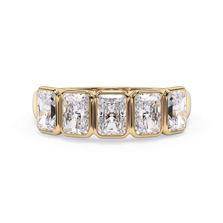 A picture of a five stone diamond wedding ring with radiant cut diamonds that are bezel set in yellow gold on a white background with the ring facing forward, lying down.