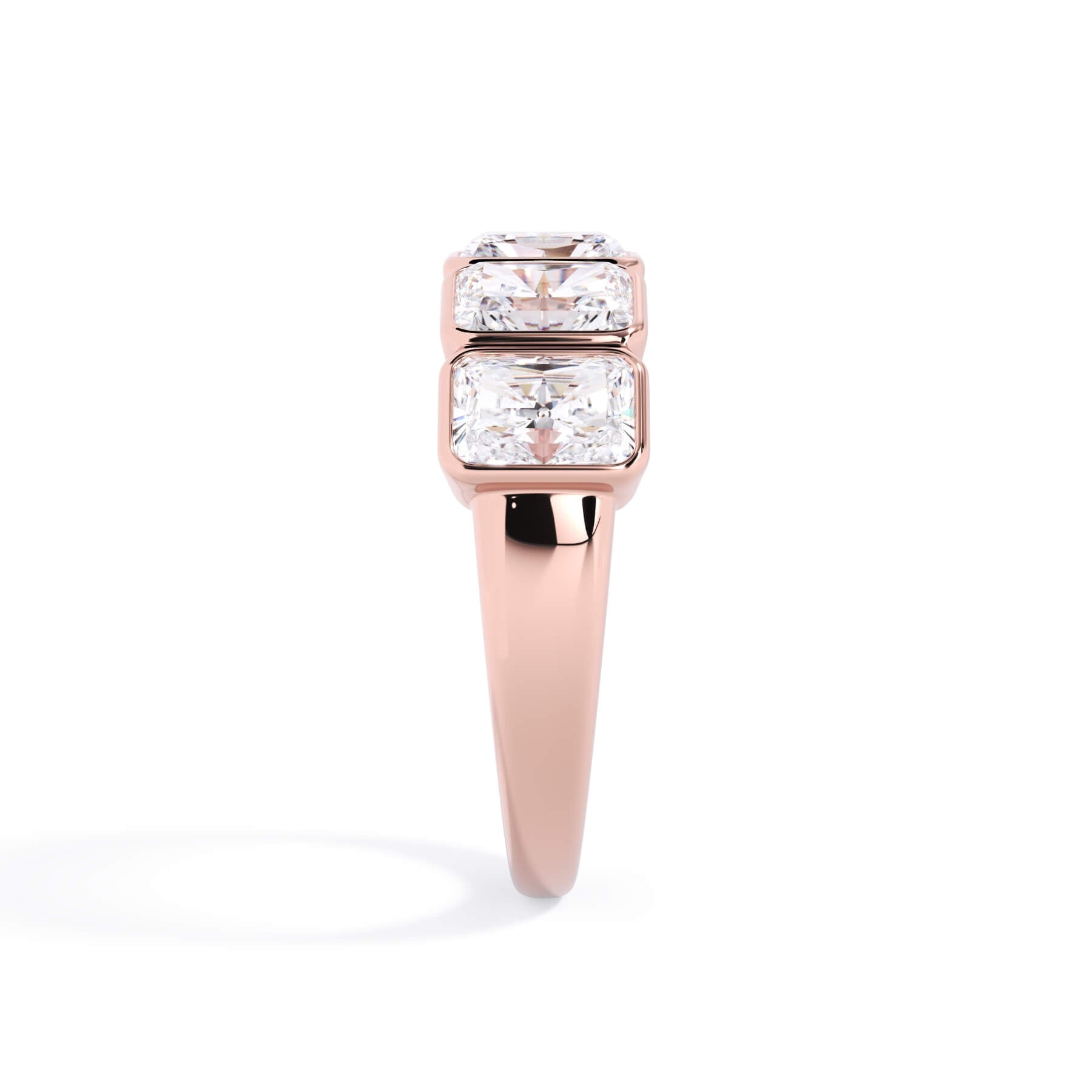 A picture of a five stone diamond wedding ring with radiant cut diamonds that are bezel set in rose gold on a white background with a side profile view.