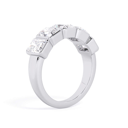 A picture of a five stone diamond wedding ring with radiant cut diamonds that are bezel set in white gold or platinum on a white background with a slightly angled, through the finger view.