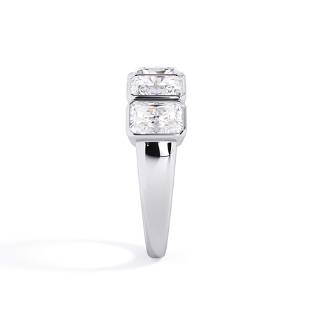 A picture of a five stone diamond wedding ring with radiant cut diamonds that are bezel set in white gold or platinum on a white background with a side profile view.