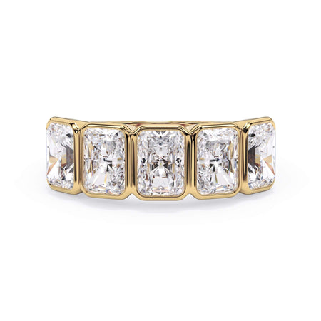 A picture of a five stone diamond wedding ring with radiant cut diamonds that are bezel set in yellow gold on a white background with the ring facing forward, lying down.