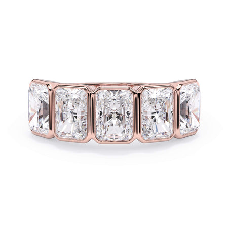 A picture of a five stone diamond wedding ring with radiant cut diamonds that are bezel set in rose gold on a white background with the ring facing forward, lying down.