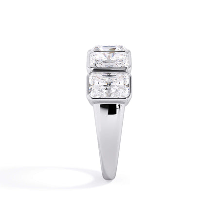 A picture of a five stone diamond wedding ring with radiant cut diamonds that are bezel set in white gold or platinum on a white background with a side profile view.