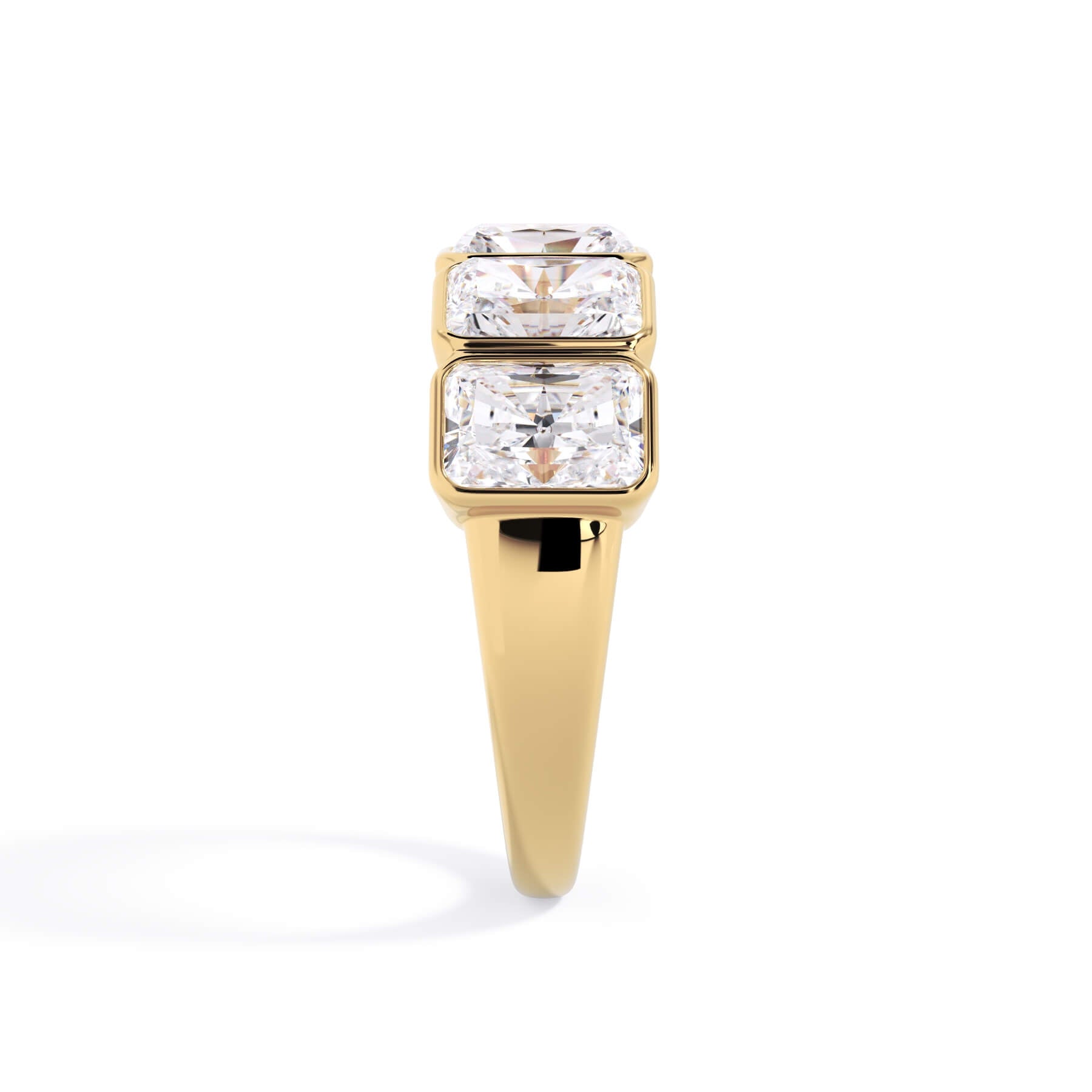A picture of a five stone diamond wedding ring with radiant cut diamonds that are bezel set in yellow gold on a white background with a side profile view.