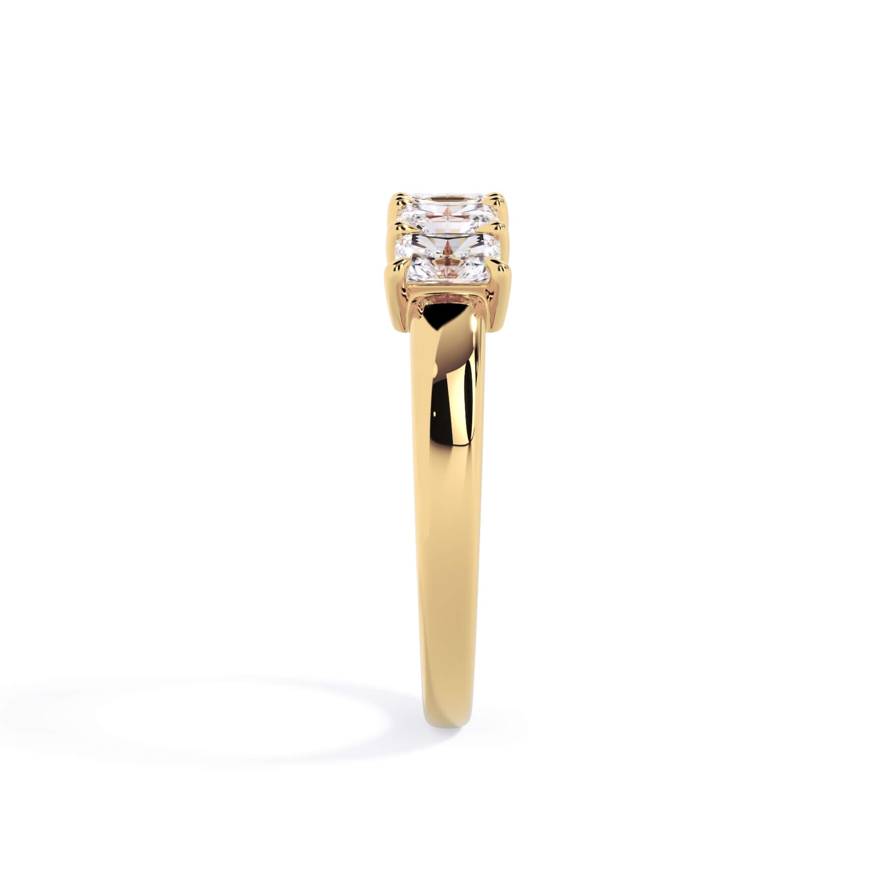 A picture of a five stone diamond wedding ring with radiant cut diamonds that are shared prong set in yellow gold on a white background with a side profile view.
