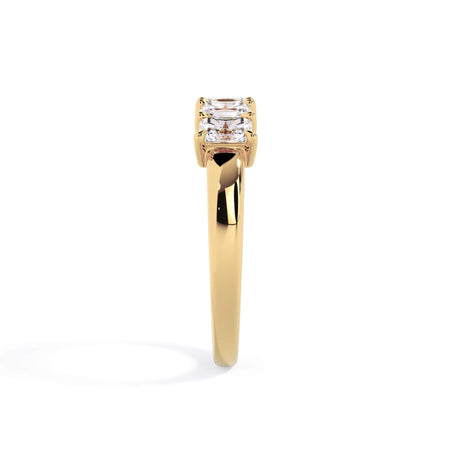 A picture of a five stone diamond wedding ring with radiant cut diamonds that are shared prong set in yellow gold on a white background with a side profile view.
