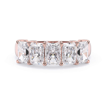 A picture of a five stone diamond wedding ring with radiant cut diamonds that are shared prong set in rose gold on a white background with the ring facing forward, lying down.