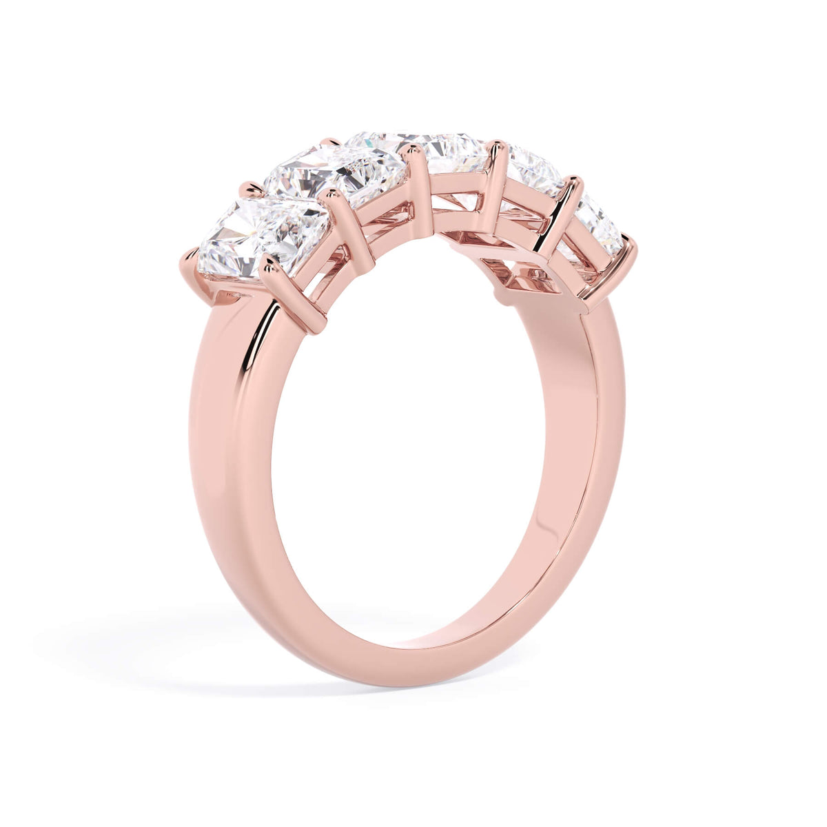 A picture of a five stone diamond wedding ring with radiant cut diamonds that are shared prong set in rose gold on a white background with a slightly angled, through the finger view.