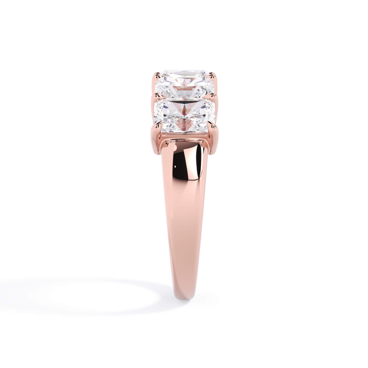 A picture of a five stone diamond wedding ring with radiant cut diamonds that are shared prong set in rose gold on a white background with a side profile view.