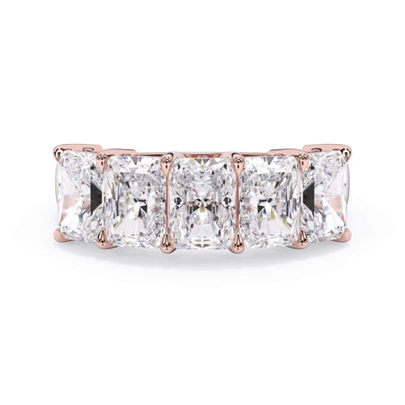 A picture of a five stone diamond wedding ring with radiant cut diamonds that are shared prong set in rose gold on a white background with the ring facing forward, lying down.