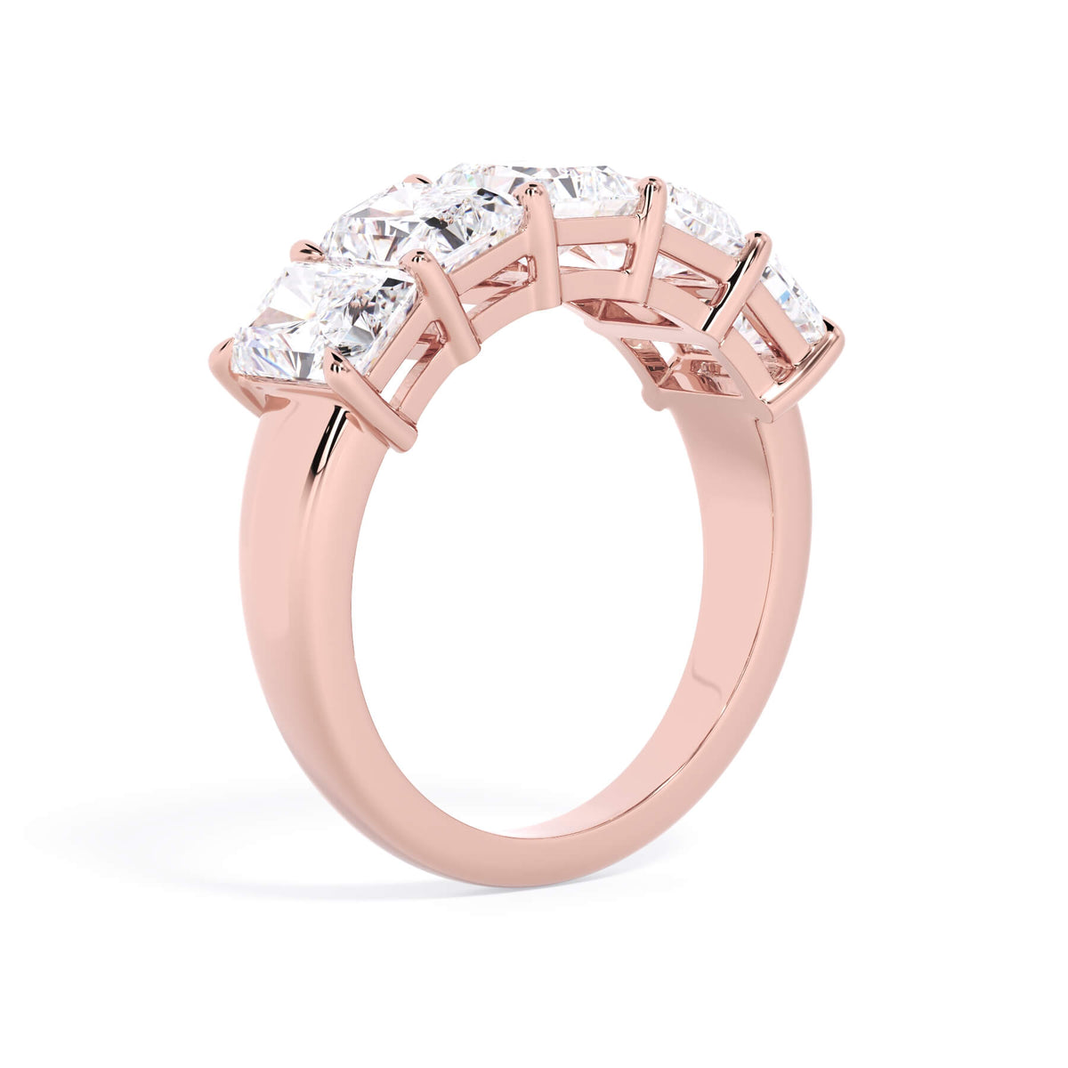 A picture of a five stone diamond wedding ring with radiant cut diamonds that are shared prong set in rose gold on a white background with a slightly angled, through the finger view.