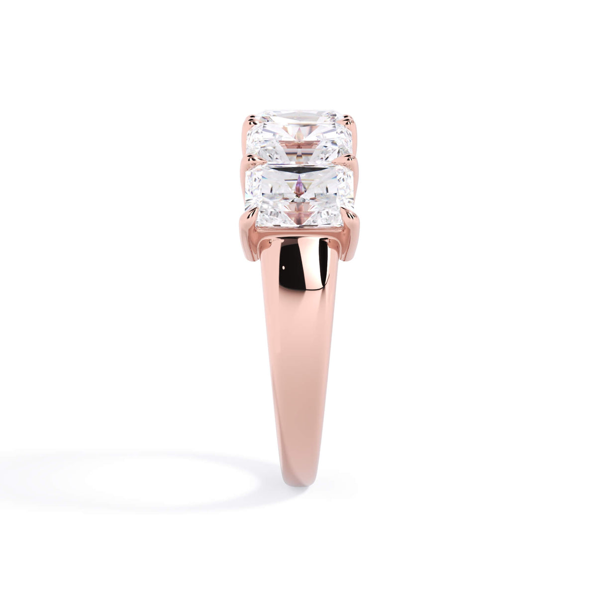 A picture of a five stone diamond wedding ring with radiant cut diamonds that are shared prong set in rose gold on a white background with a side profile view.