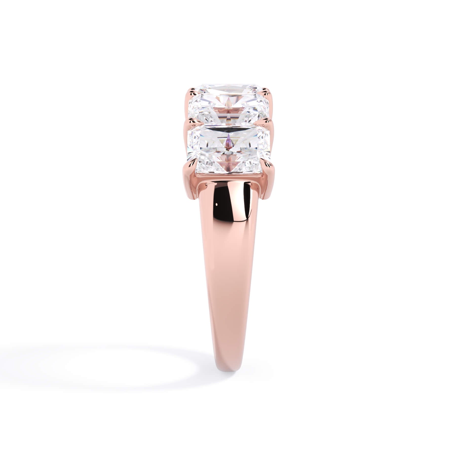 A picture of a five stone diamond wedding ring with radiant cut diamonds that are shared prong set in rose gold on a white background with a side profile view.