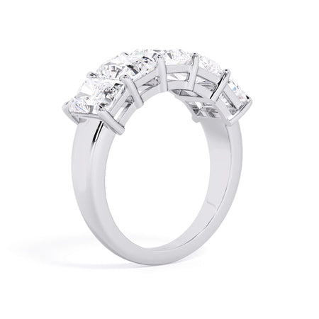 A picture of a five stone diamond wedding ring with radiant cut diamonds that are shared prong set in white gold or platinum on a white background with a slightly angled, through the finger view.