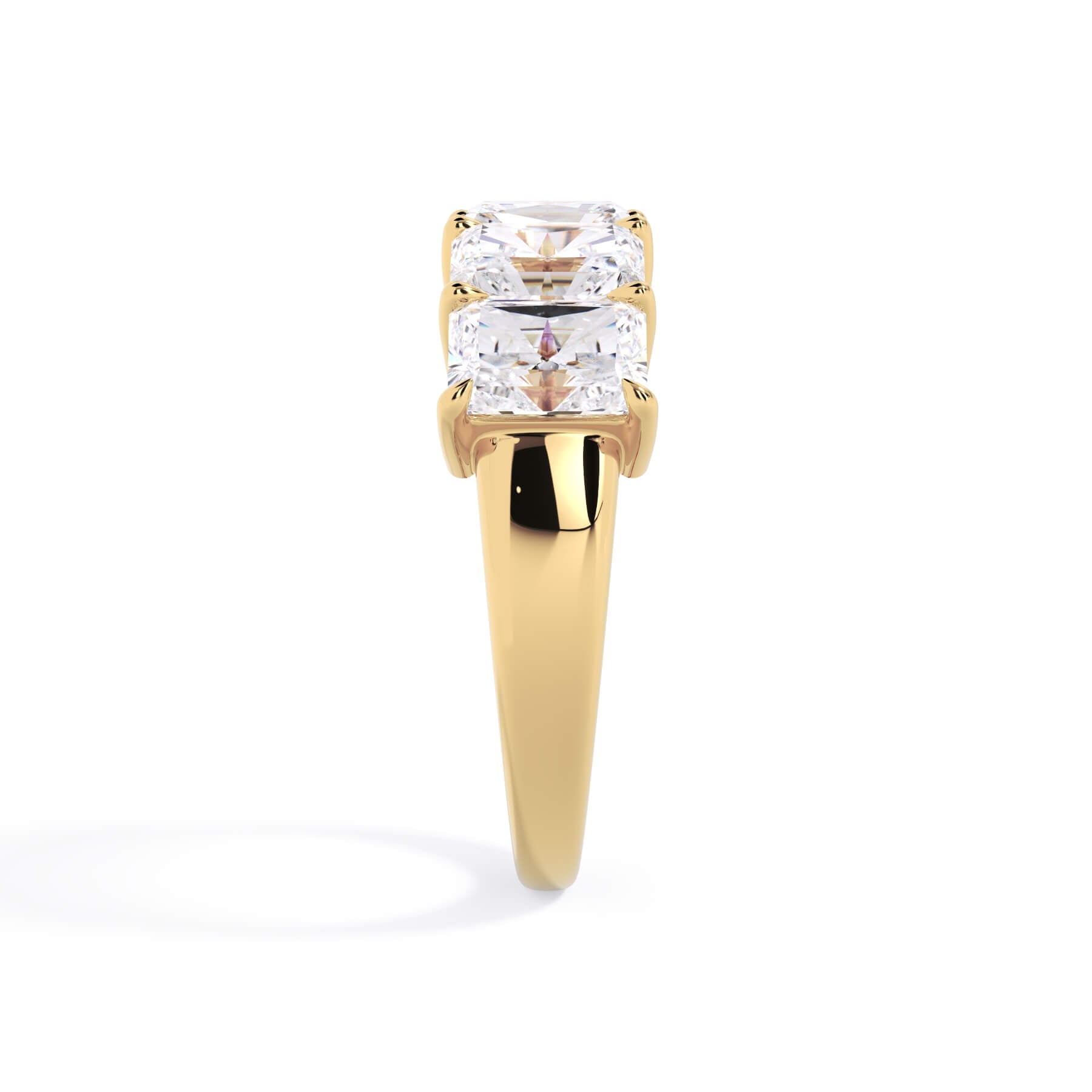 A picture of a five stone diamond wedding ring with radiant cut diamonds that are shared prong set in yellow gold on a white background with a side profile view.