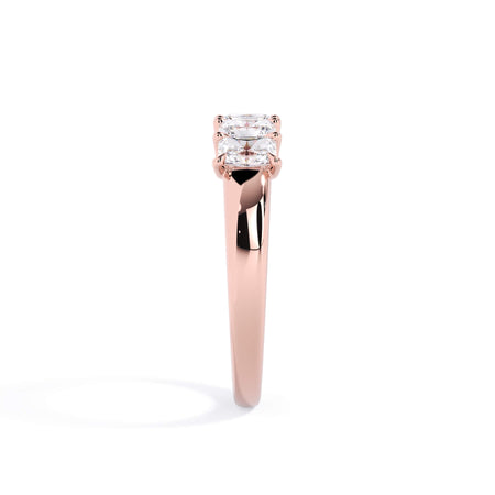 A picture of a five stone diamond wedding ring with radiant cut diamonds that are u prong set in rose gold on a white background with a side profile view.