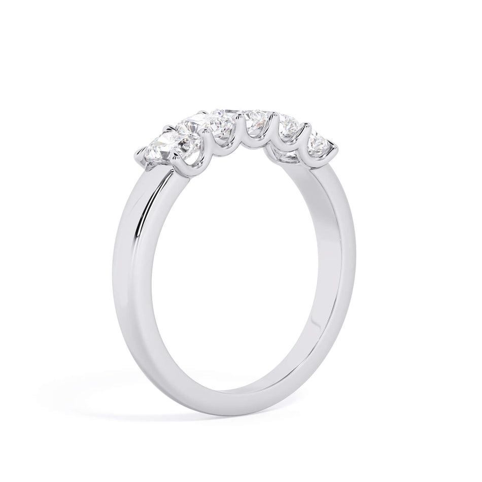 A picture of a five stone diamond wedding ring with radiant cut diamonds that are u prong set in white gold or platinum on a white background with a slightly angled, through the finger view.
