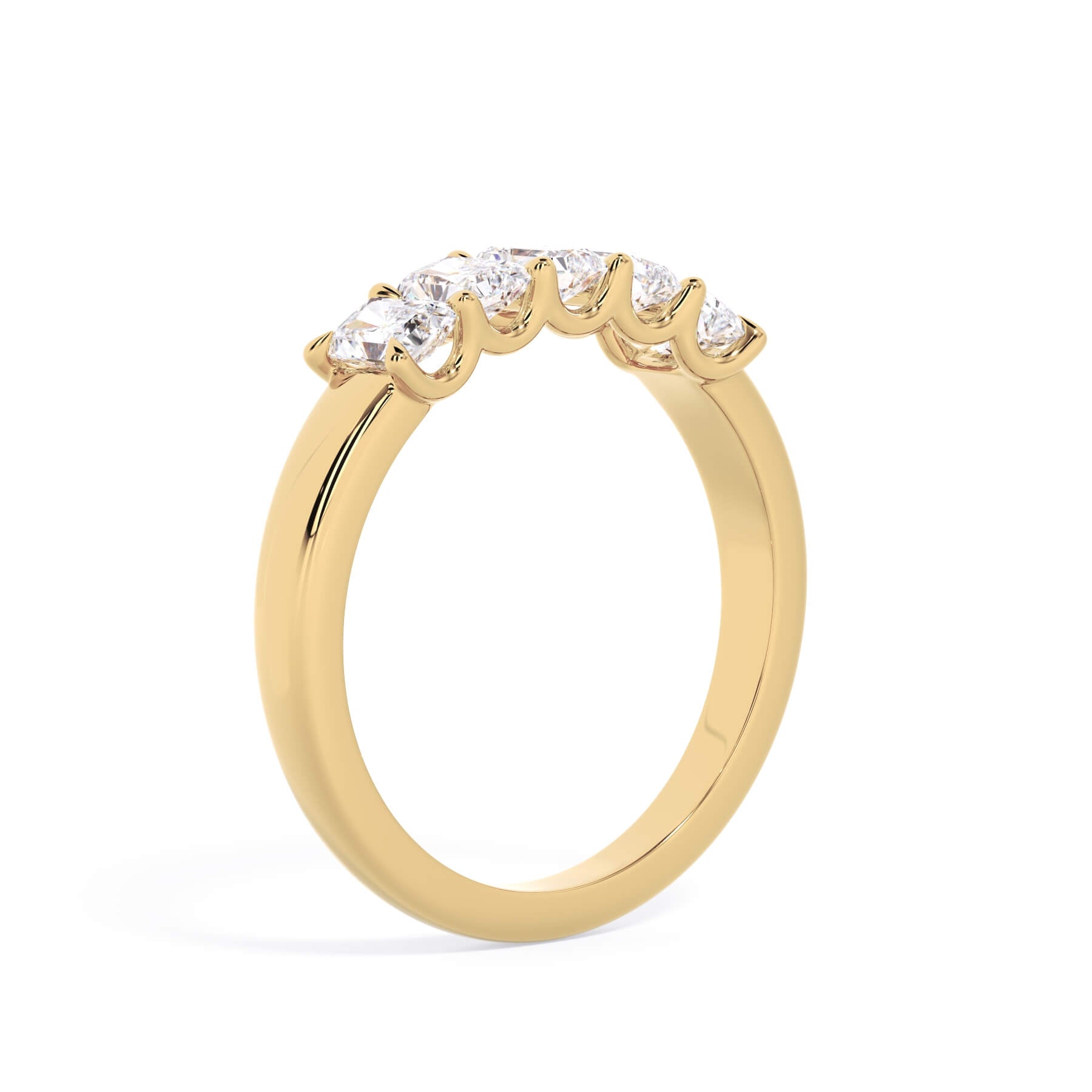 A picture of a five stone diamond wedding ring with radiant cut diamonds that are u prong set in yellow gold on a white background with a slightly angled, through the finger view.