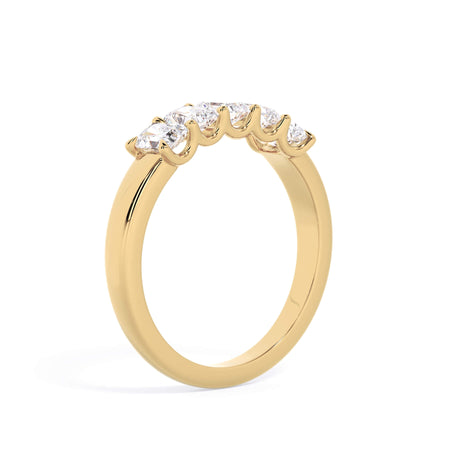 A picture of a five stone diamond wedding ring with radiant cut diamonds that are u prong set in yellow gold on a white background with a slightly angled, through the finger view.