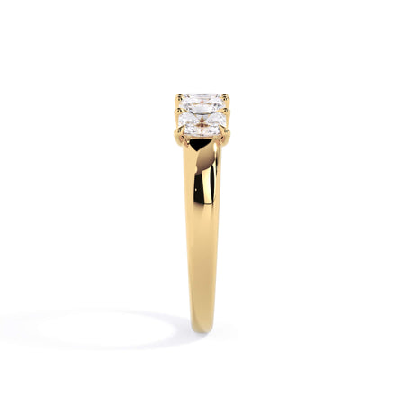 A picture of a five stone diamond wedding ring with radiant cut diamonds that are u prong set in yellow gold on a white background with a side profile view.