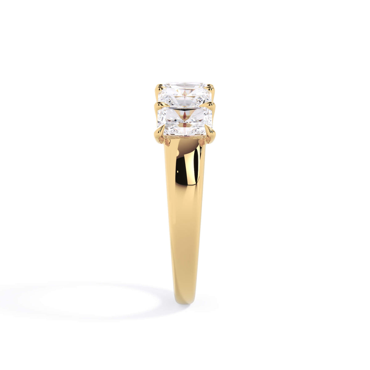 A picture of a five stone diamond wedding ring with radiant cut diamonds that are u prong set in yellow gold on a white background with a side profile view.