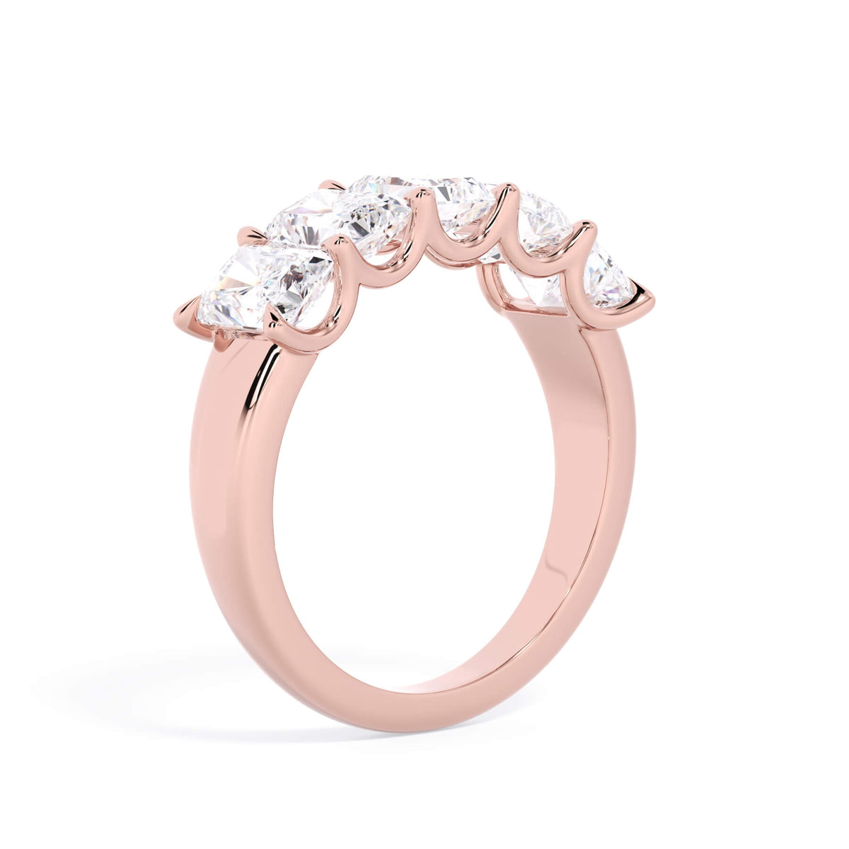 A picture of a five stone diamond wedding ring with radiant cut diamonds that are u prong set in rose gold on a white background with a slightly angled, through the finger view.