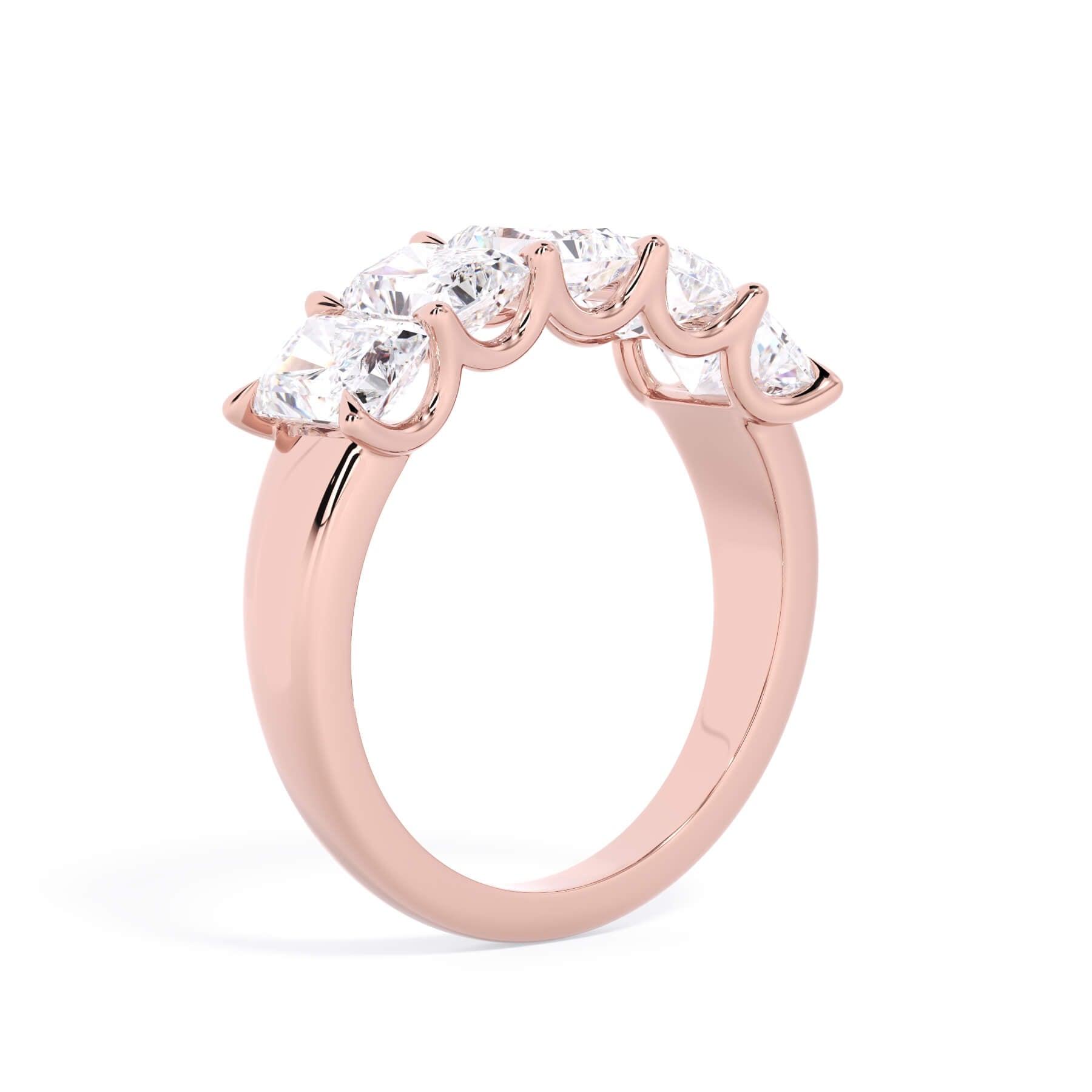 A picture of a five stone diamond wedding ring with radiant cut diamonds that are u prong set in rose gold on a white background with a slightly angled, through the finger view.