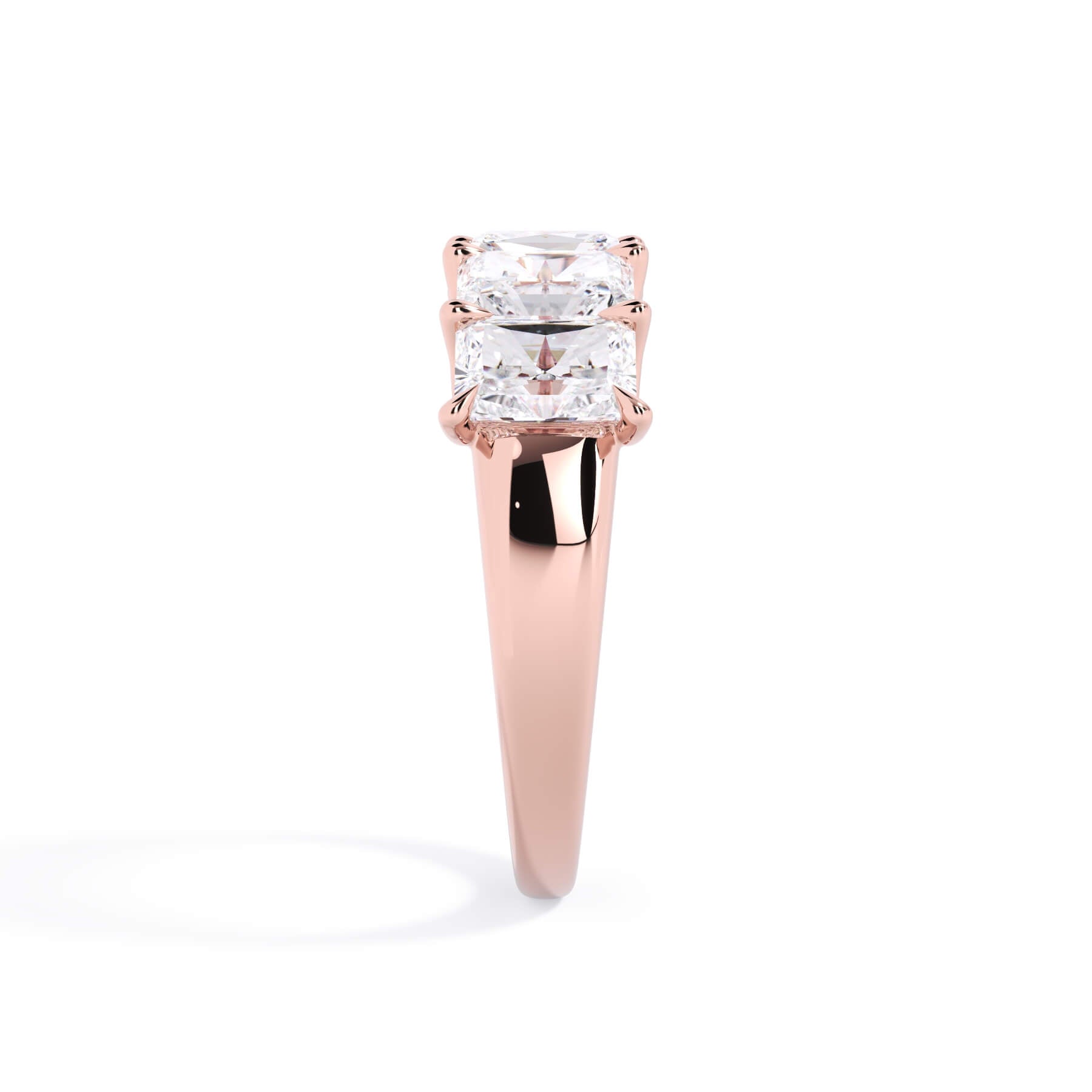 A picture of a five stone diamond wedding ring with radiant cut diamonds that are u prong set in rose gold on a white background with a side profile view.