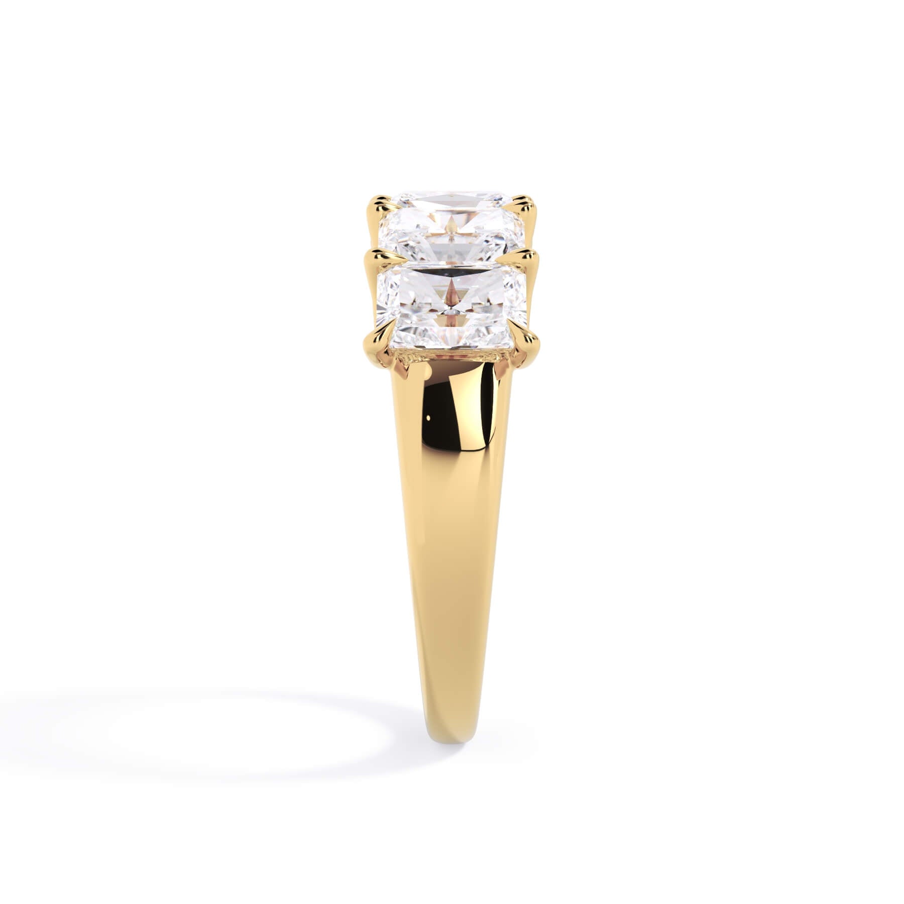 A picture of a five stone diamond wedding ring with radiant cut diamonds that are u prong set in yellow gold on a white background with a side profile view.