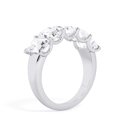 A picture of a five stone diamond wedding ring with radiant cut diamonds that are u prong set in white gold or platinum on a white background with a slightly angled, through the finger view.