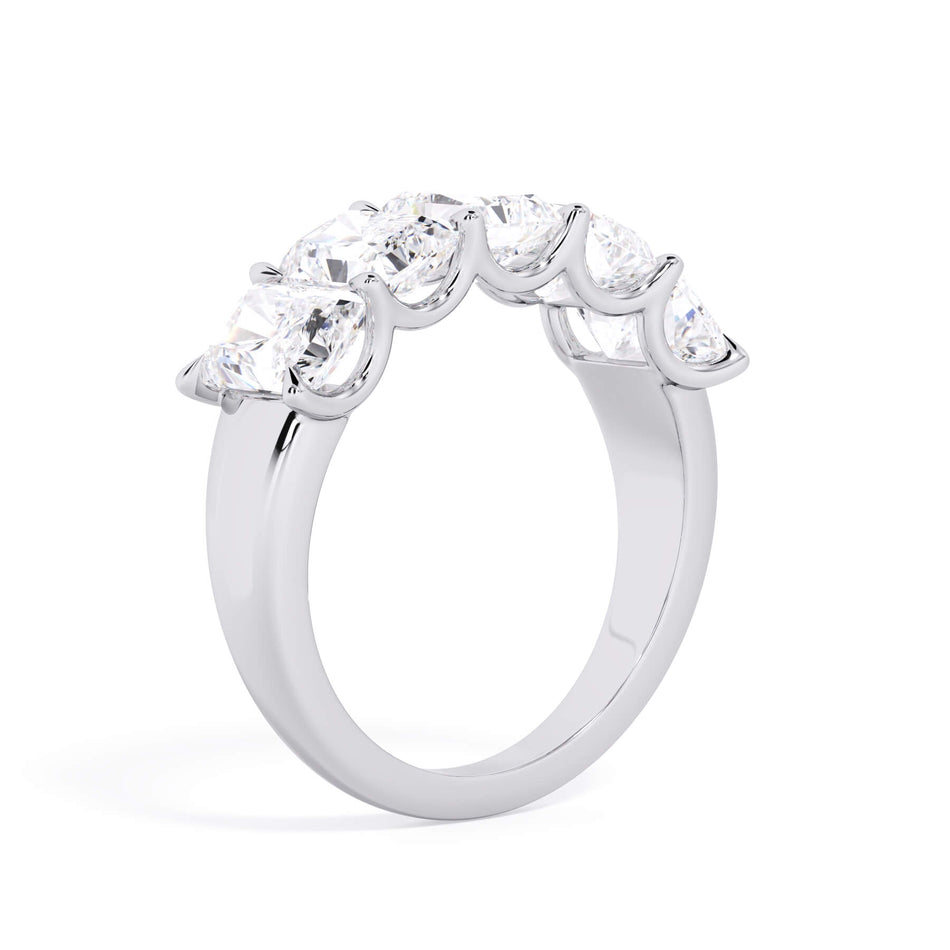 A picture of a five stone diamond wedding ring with radiant cut diamonds that are u prong set in white gold or platinum on a white background with a slightly angled, through the finger view.