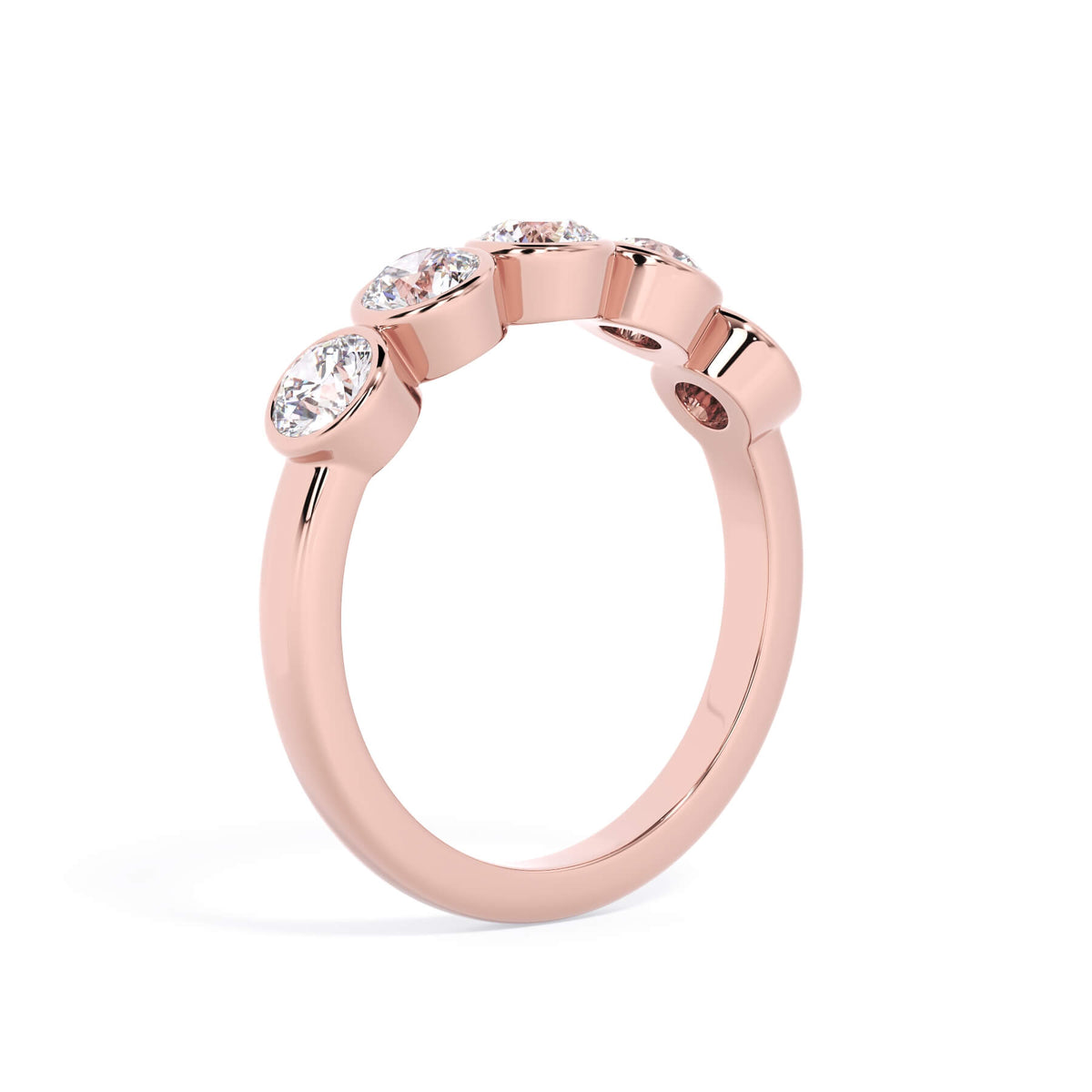 A picture of a five stone diamond wedding ring with round diamonds that are bezel set in rose gold on a white background with a slightly angled, through the finger view.