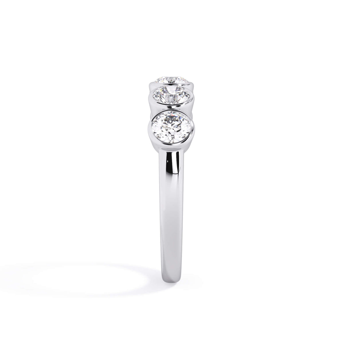 A picture of a five stone diamond wedding ring with round diamonds that are bezel set in white gold or platinum on a white background with a side profile view.