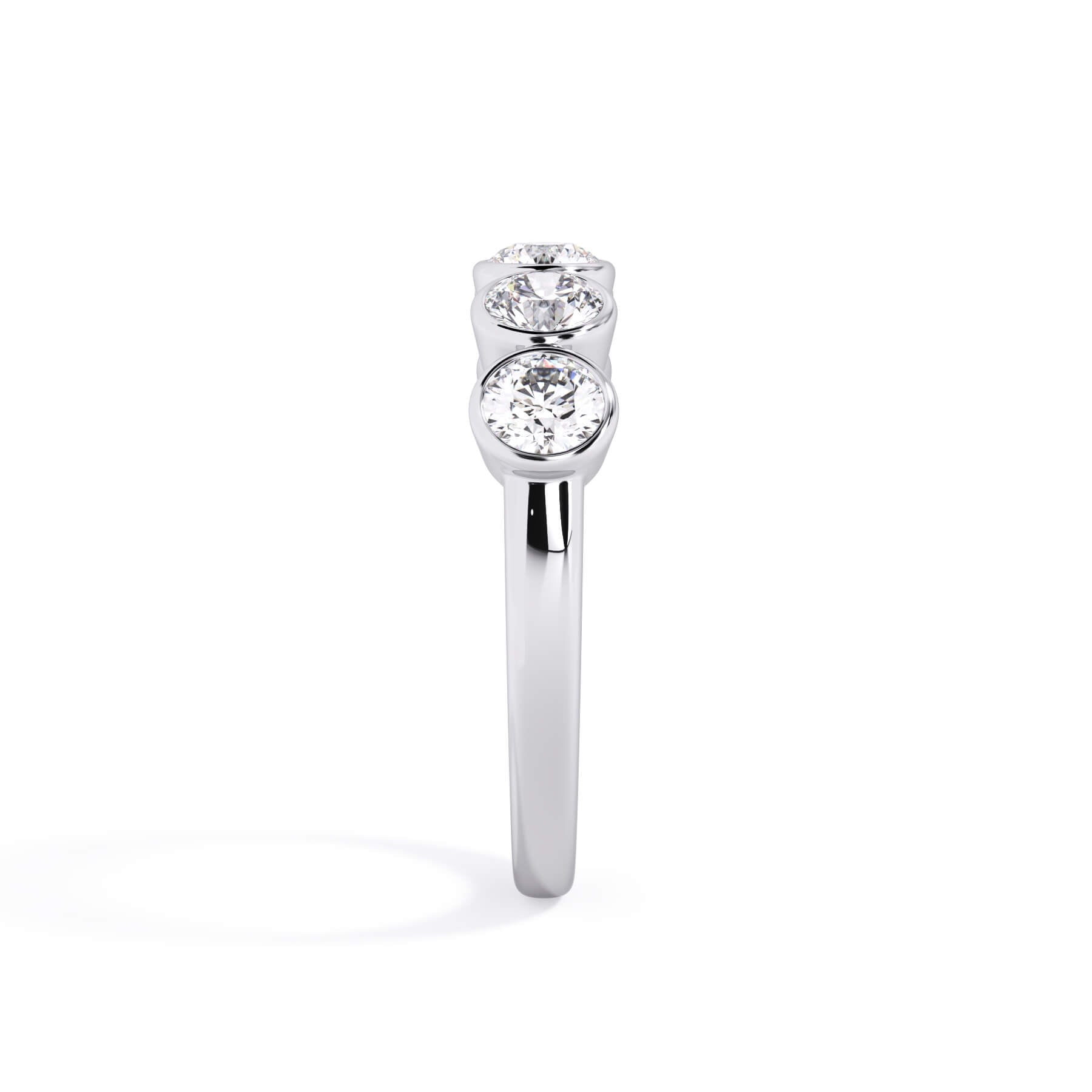 A picture of a five stone diamond wedding ring with round diamonds that are bezel set in white gold or platinum on a white background with a side profile view.