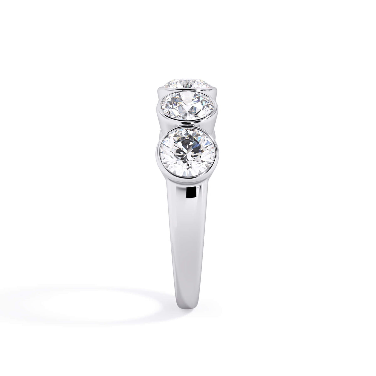 A picture of a five stone diamond wedding ring with round diamonds that are bezel set in white gold or platinum on a white background with a side profile view.