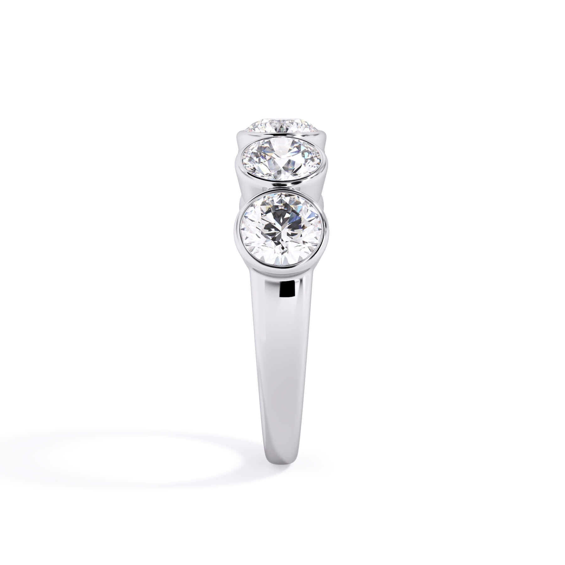 A picture of a five stone diamond wedding ring with round diamonds that are bezel set in white gold or platinum on a white background with a side profile view.